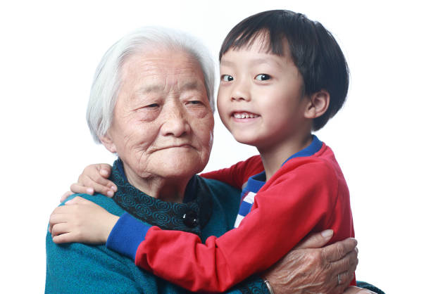 Grandmother gazing upon her grandson lovingly with a red brick wall in the background. Photo was taken in Hot Springs Village, Arkansas.