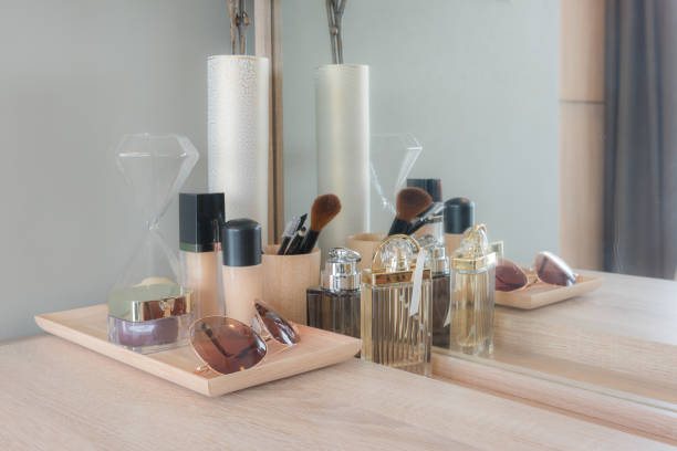 Beauty and make-up concept: table mirror, flowers, perfume, jewelry and makeup brushes on wooden table stock photo