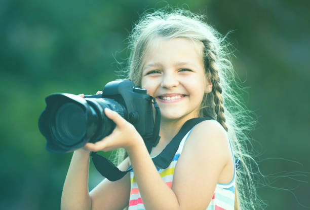 istock little girl with camera outdoors 647141002