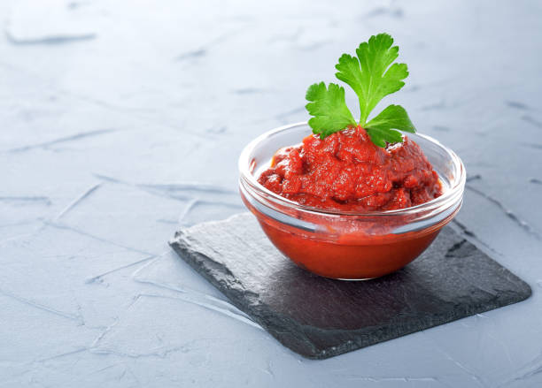 istock tomato paste in a glass bowl on a black stone 647141276