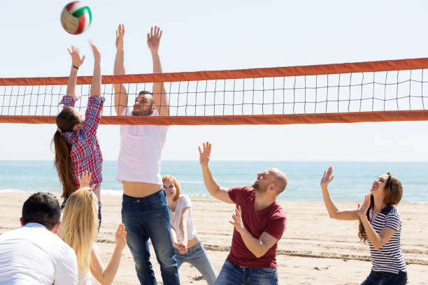 istock People play volleyball on beach 647141378