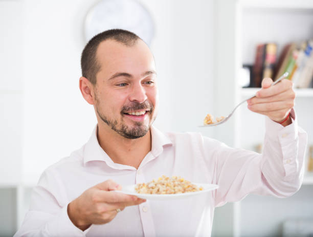 istock Positive young man eating porridge 647142000