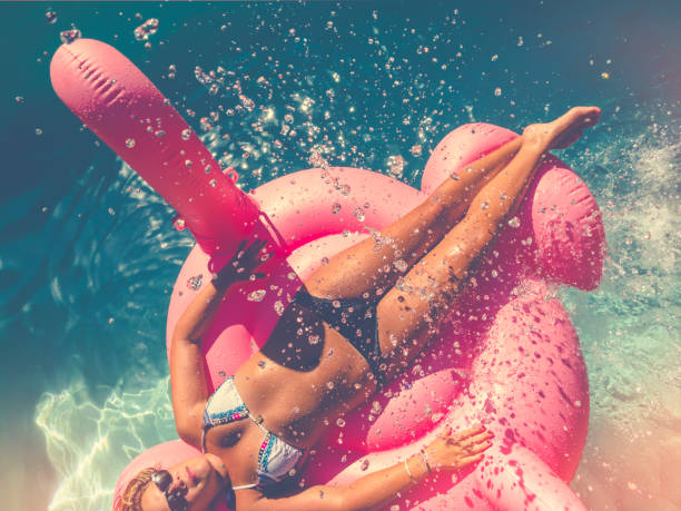 istock Woman floating on a pink inflatable in swimming pool. 647142086