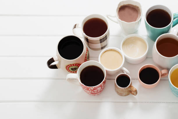 istock Many cups of  hot drinks on white wooden table 647145102