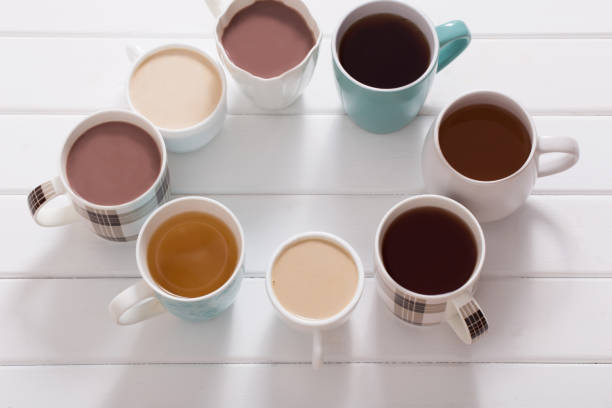 istock Many cups of  hot drinks on white wooden table 647145104