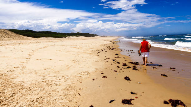 istock Lady walking on the sand on a cloudy day 647154136