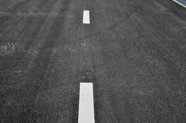 istock Concept of the transportation. Textural broken lines on the asphalt road surface. 647160754