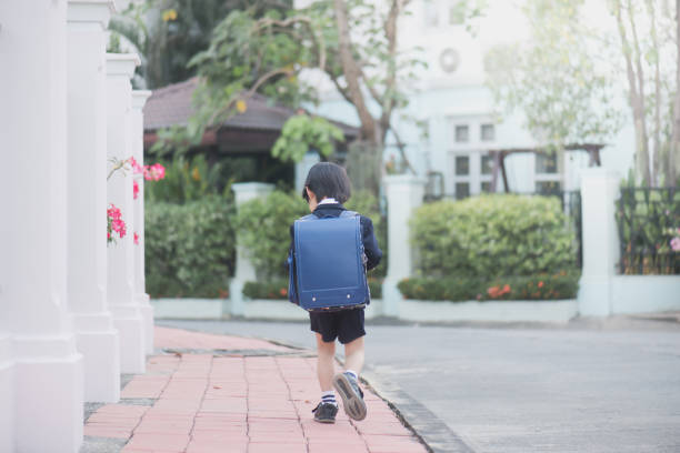 istock Asian school girl with pink backpack looking up 647167718