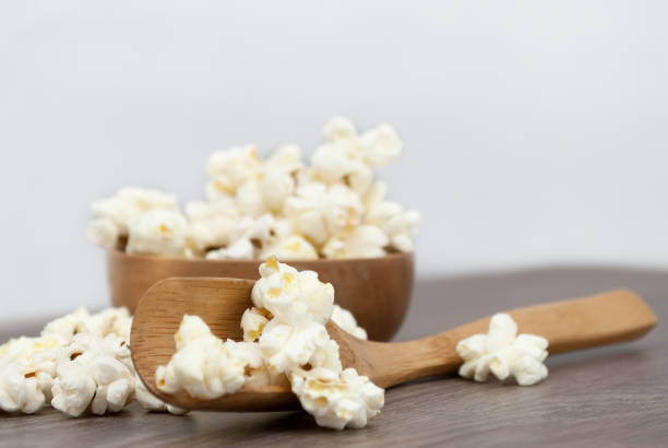 istock Popcorn in small wooden bowl on vintage boards. Selective focus. 647167792