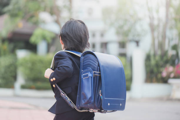 Asian school girl with pink backpack looking up Portrait of Asian student with backpack outdoors,back to school concept randoseru stock pictures, royalty-free photos & images