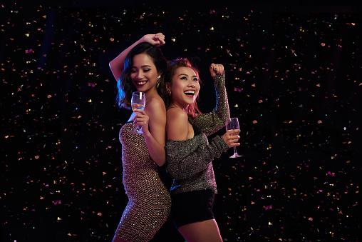 Gorgeous Vietnamese female friends dancing in night club
