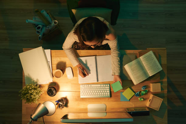 Studying at night Female student doing homework, view from above homework books stock pictures, royalty-free photos & images