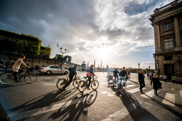 People cycling on Rue de Rivoli in Paris, France stock photo