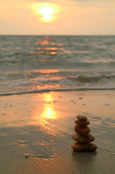 istock Piled up pebble stones on the sunset beach 647188456