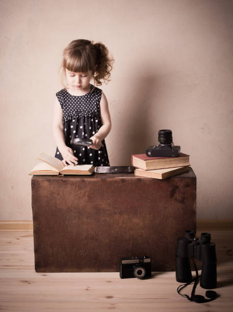 istock little girl reading book with magnifier 647191074