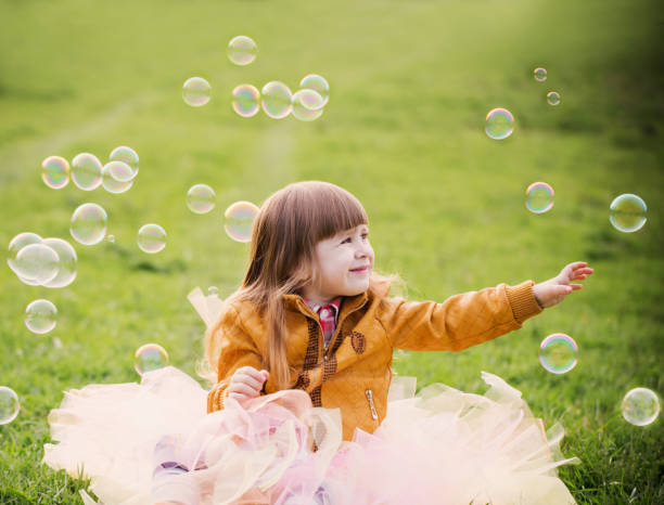 istock little girl is playing with bubbles in a park 647191256