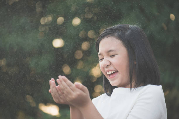 istock asian girl is happy with the rain 647207342