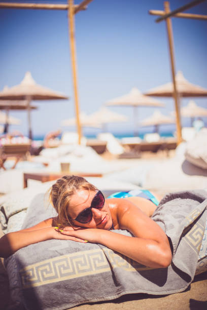 istock Beautiful woman sunbathing relaxing on a beach 647209540