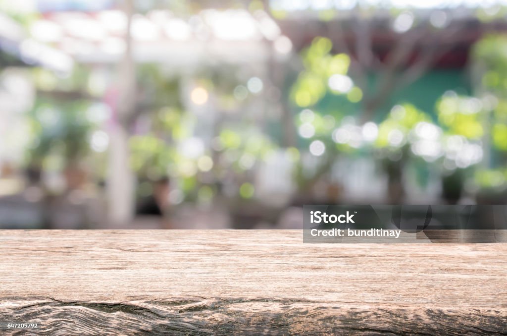 Wood table top and blurred restaurant exterior background. Wood table top background - can used for display or montage your products. Outdoors Stock Photo