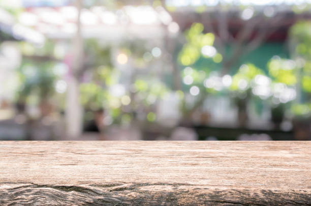 Wood table top and blurred restaurant exterior background. Wood table top background - can used for display or montage your products. bar exterior stock pictures, royalty-free photos & images