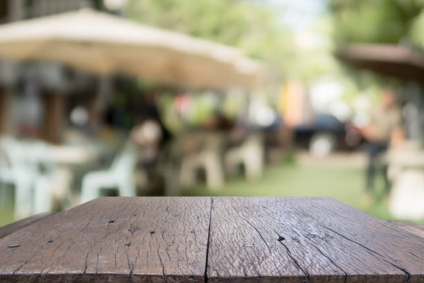 istock Wood table top and blurred restaurant exterior background. 647209940