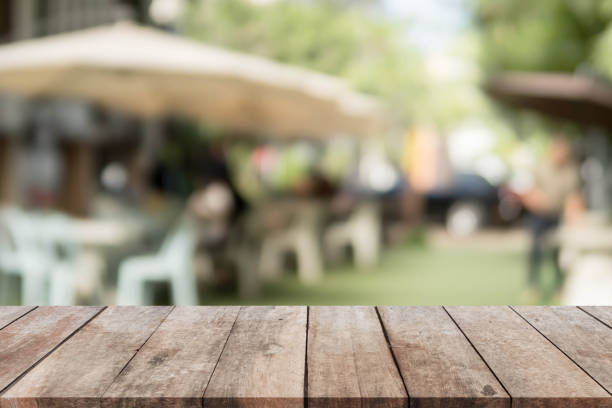 istock Wood table top and blurred restaurant exterior background. 647209942