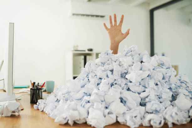 Admin can be overwhelming once it piles up Shot of an unidentifiable businesswoman drowning under a pile of paperwork in the office buried stock pictures, royalty-free photos & images