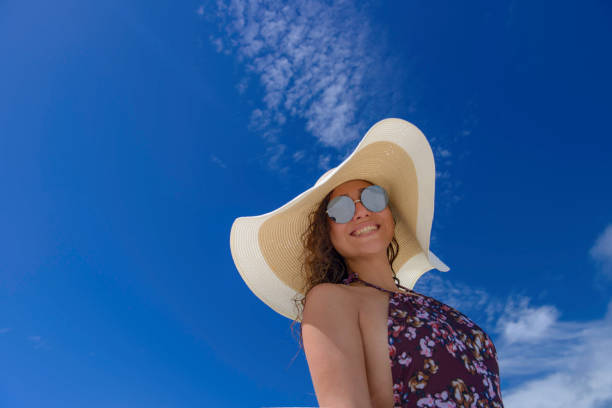 istock Young Adult Woman Smiling under Blue Sky 647224976