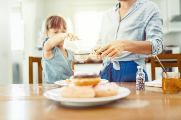 istock Mother and daughter making sweet donuts in the kitchen 647228264