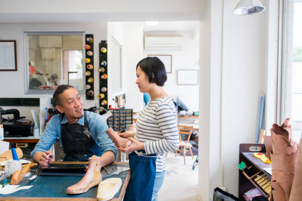 istock Team of shoemakers talking 647228744