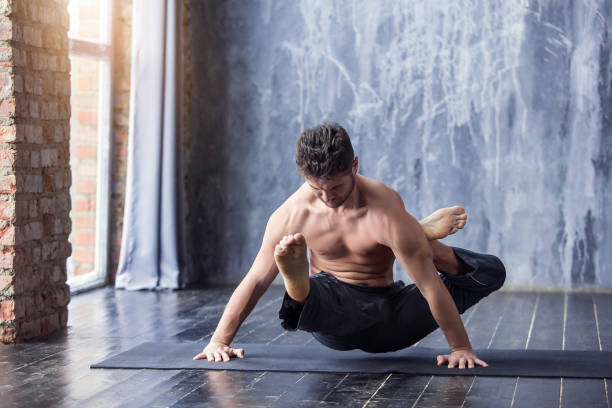 istock Young man doing an asana ashtavakrasana 647231904