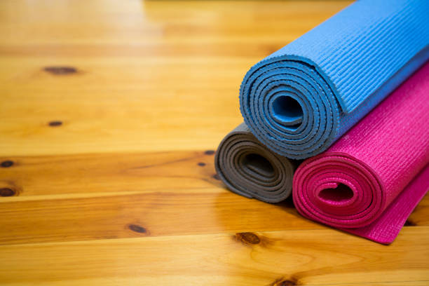 istock Rolled-up exercise mat on wooden floor 647232074