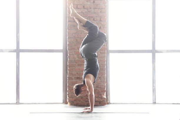istock Young man practicing yoga in a urban background 647235954