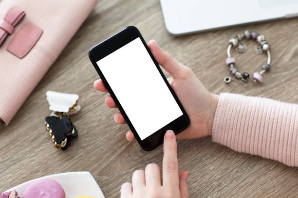 istock female hand holding phone with isolated screen on table 647239812