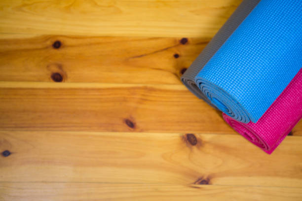 istock Rolled-up exercise mat on wooden floor 647240292