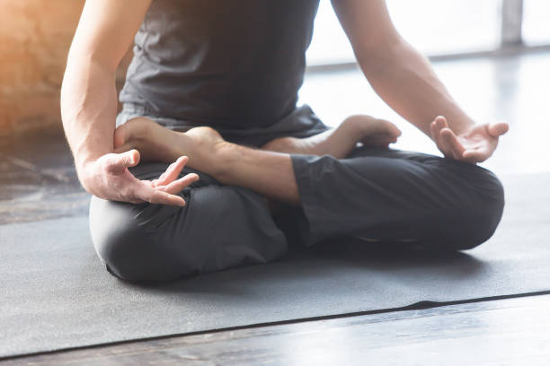 istock Young men do yoga indoors on black mat 647240338