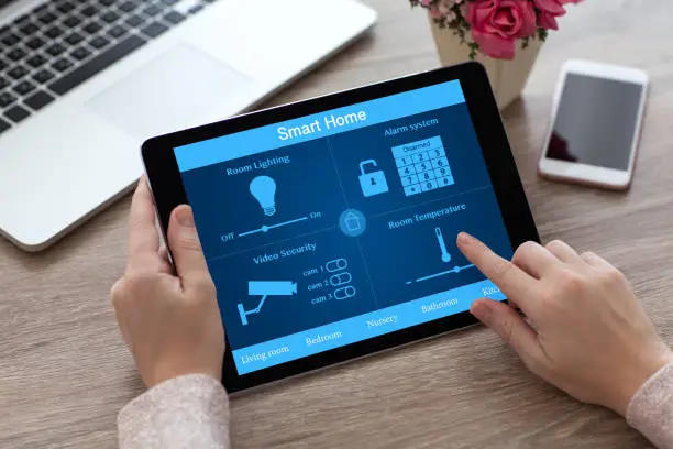 Photo of woman hands holding tablet PC computer smart home near laptop