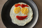 istock Happy face breakfast, Smiling fried egg by ketchup. 647243078