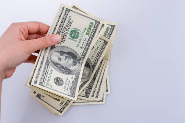 istock Human hand holding American dollar banknotes on white background 647247260