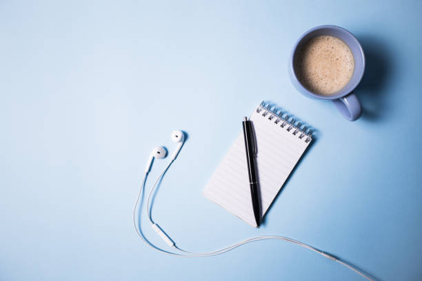 istock Office supplies. Top view on opened notebook, pen, headphone 647252470