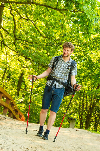 istock young man with backpack hiking in forest trail 647259120