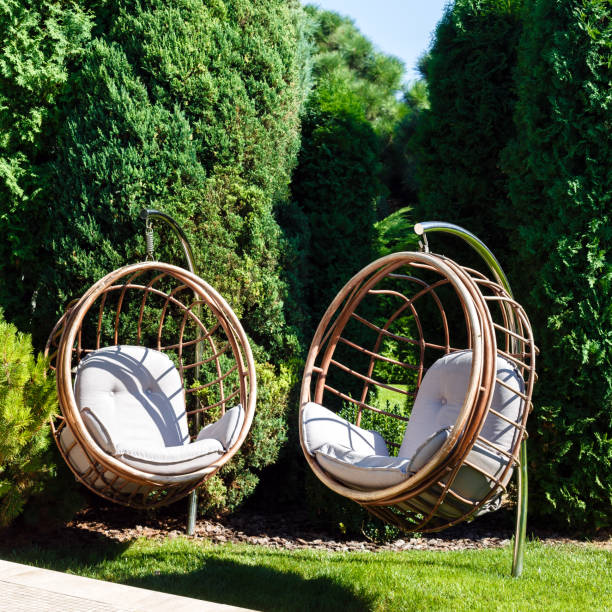 istock Two hanging chairs in the garden on a sunny summer day. 647269280