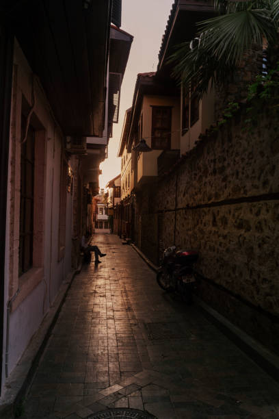 Street view of Kaleici in Antalya. A boy sitting and playing with his cellphone. Antalya is the largest Turkish city on the Mediterranean coast with over one million people in its metropolitan area. Kaleici, also known as Old Antalya, is the small historic section at the center of the modern city with meandering streets.