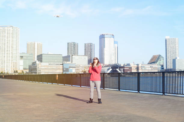 istock Young woman playing with drone 647284030