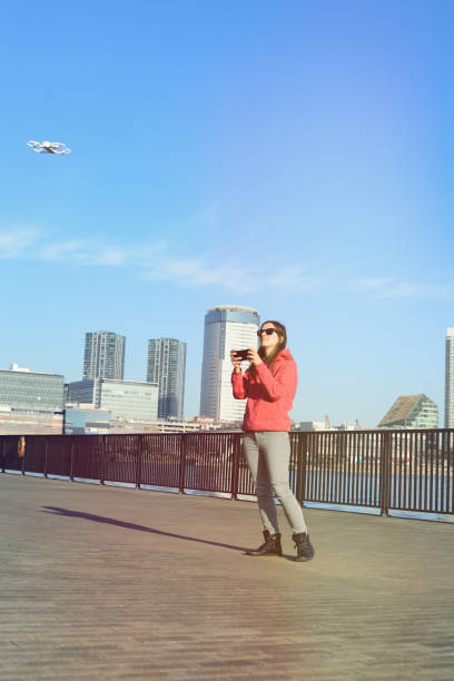 istock Young woman playing with drone 647284038