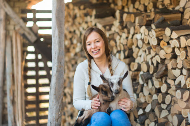istock Eastern Europe: Lifestyle-Young woman hugging kid goat 647297206