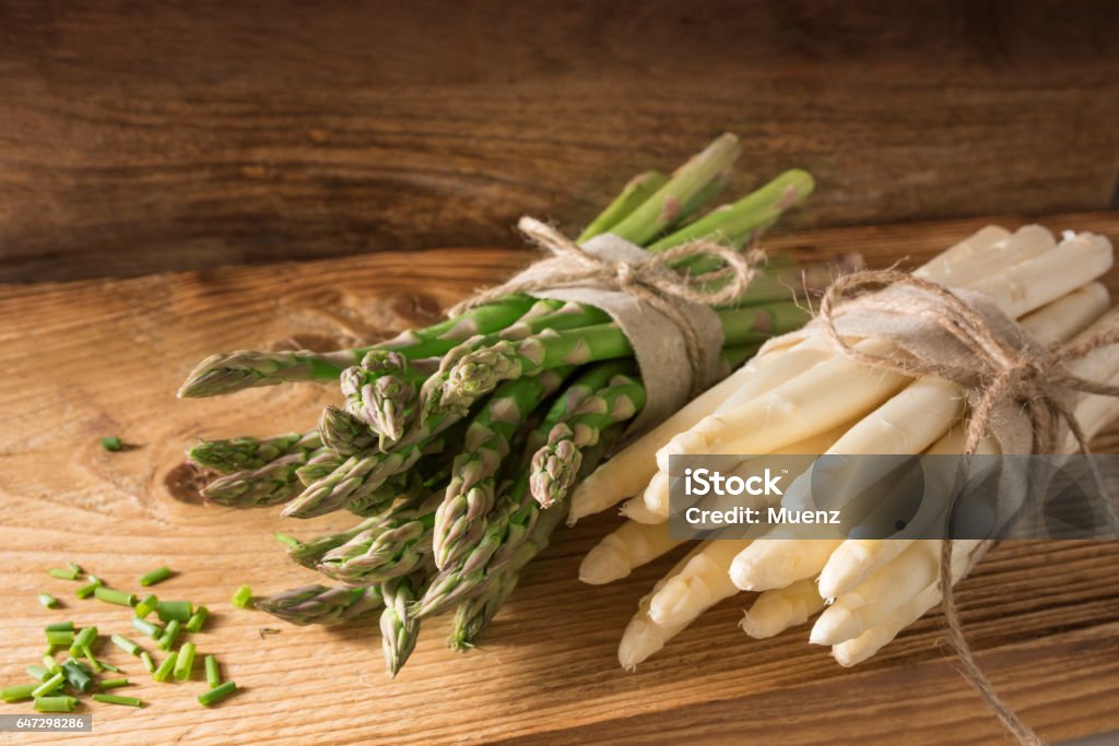 Fresh asparagus on rustic wood Fresh green and white asparagus with chopped parsley on rustic wood Asparagus Stock Photo