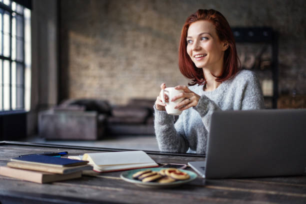 istock Young woman working in a loft apartment with a laptop computer 647301914