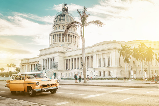 old orange american car in front of Capitol in Havanna