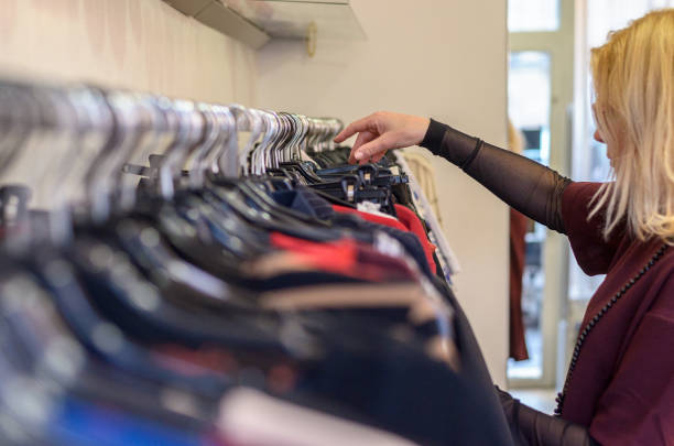 istock Female shopper searching through garments 647309184